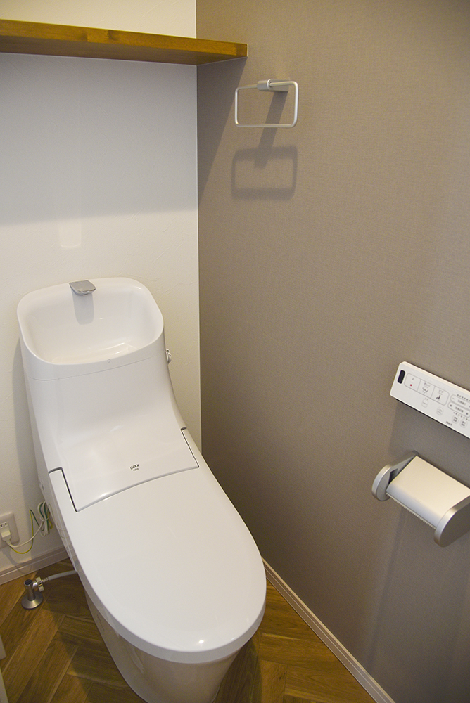 ２階トイレ（便器：LIXIL ベーシアシャワートイレ／クロス：シンコール SLP-834／クッションフロア：サンゲツ HM-4029／棚：ミディアムブラウン塗装）