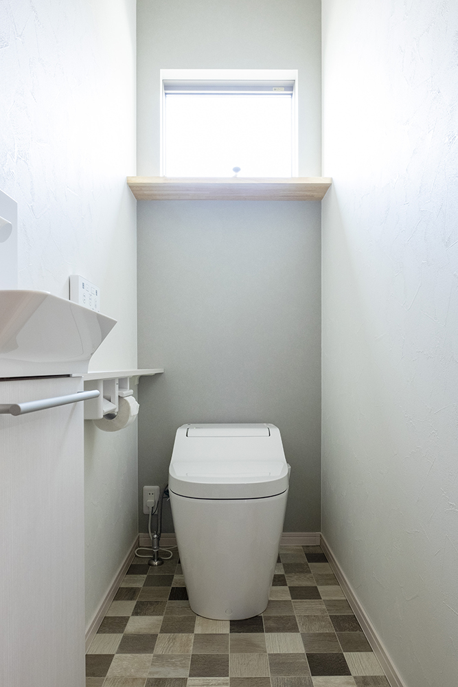 標準仕様の１階トイレ（便器：Panasonic アラウーノS2 / 手洗い：ホワイトアッシュ柄 / 正面クロス：サンゲツ FE6140 / クッションフロア：サンゲツ HM-4088）