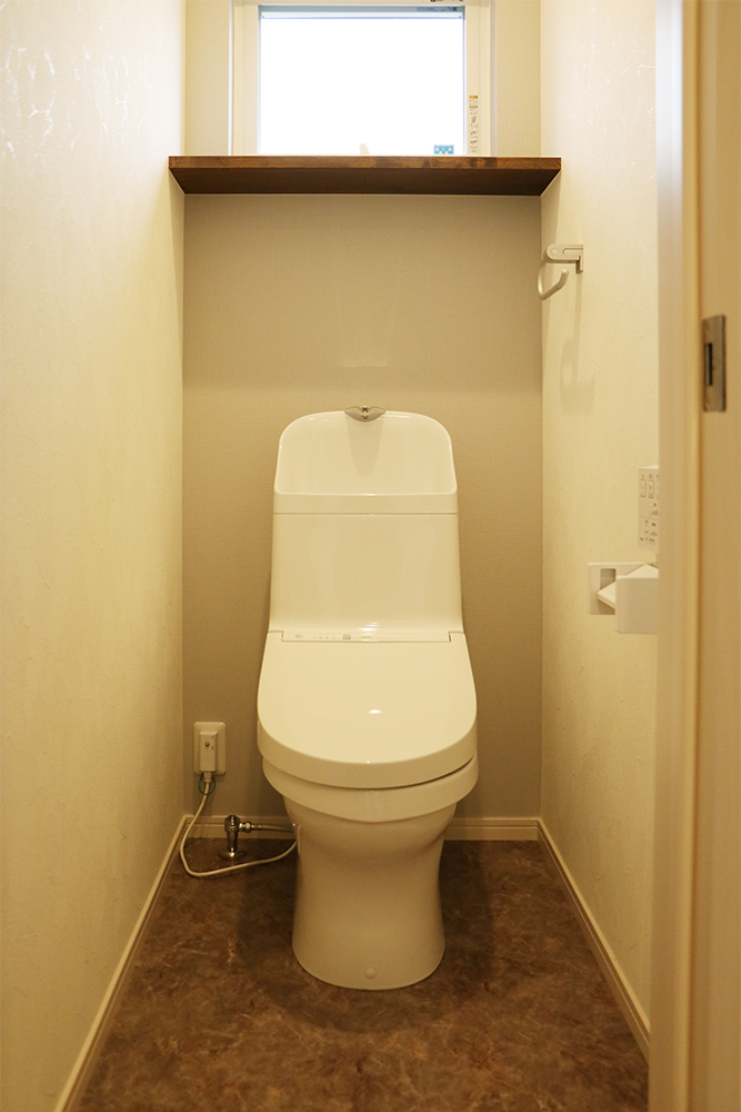 標準の２階トイレ（便器：TOTO ZJ1／クロス：シンコール SLP840／クッションフロア：サンゲツ HM-4109／棚：ウォールナット塗装）