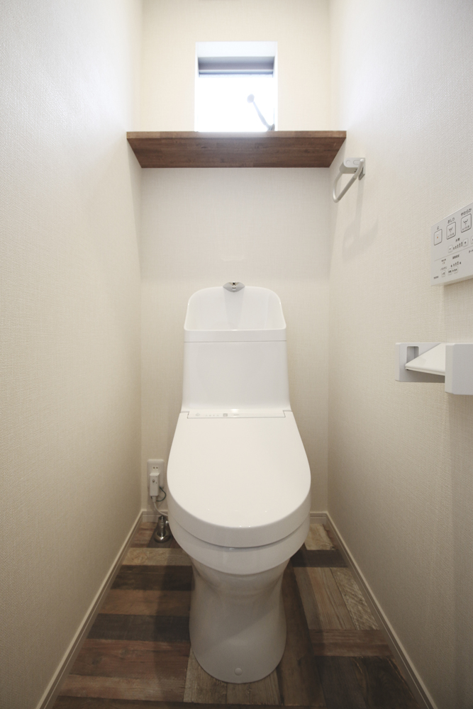２階の標準トイレ（便器：TOTO  ZJ1／クロス：シンコール SLP-810／クッションフロア：サンゲツ 店舗用 CM-4209／棚：ゴム集成材 レッドオーク塗装）