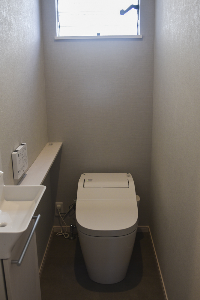 グレイッシュで素敵な１Fトイレ（トイレ背面アクセントクロス：SLP-840　フロア：HM-4090 トイレカウンター：Panasonicアラウーノ手洗い　ホワイトアッシュ）