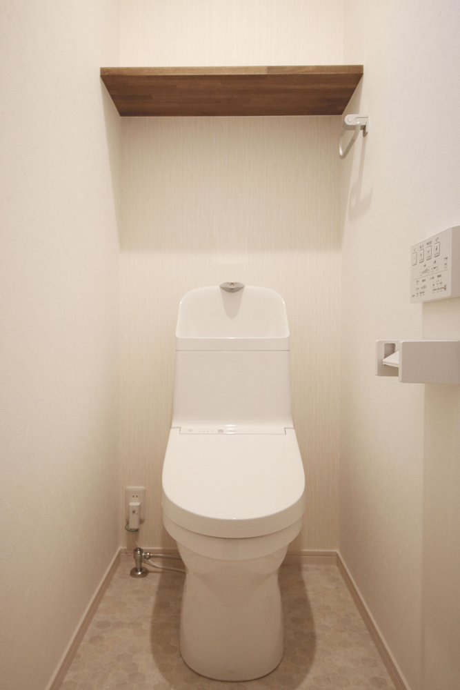 標準の２階トイレ（便器：TOTO ZJ1／奥面クロス：シンコール SLP-825／クッションフロア：サンゲツ HM-4076 廃番品／棚：ゴム集成材 オーク塗装）
