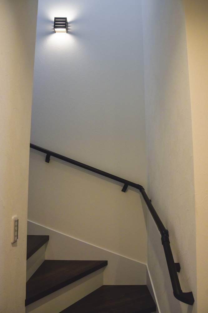 階段（踏み板：NODA アートクチュール オールドシダー柄チョコレート色／蹴込み・側板：シルキーホワイト色／手摺：ブラック／照明：DAIKO DBK-38615Y）
