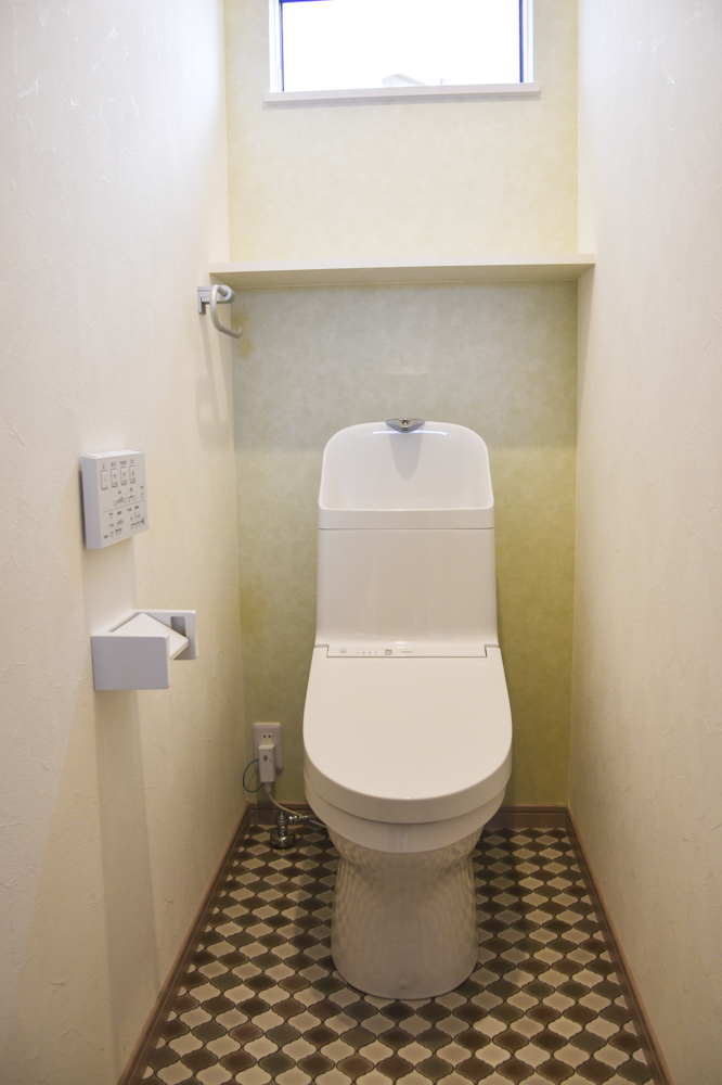 標準の２階トイレ（便器：TOTO ZJ1／奥面クロス：シンコール SLP-869／クッションフロア：サンゲツ HM-4137／棚：南海プライウッド アートランバー シェルホワイト）
