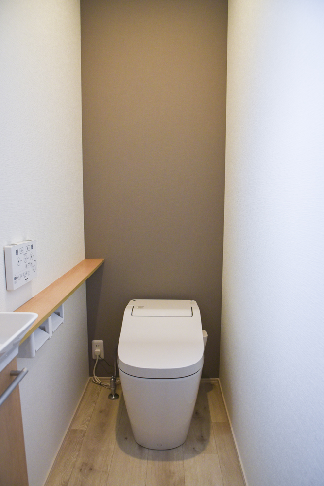 １階の標準トイレ（便器：Panasonic アラウーノS141／手洗い：Panasonic アラウーノ手洗い ソフトオーク／背面クロス：シンコール SLP-834／クッションフロア：シンコール CES-2321）