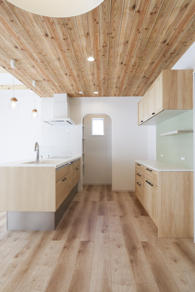 フロア材や天井などに合わせナチュラルカラーでまとめられたキッチンスペース
