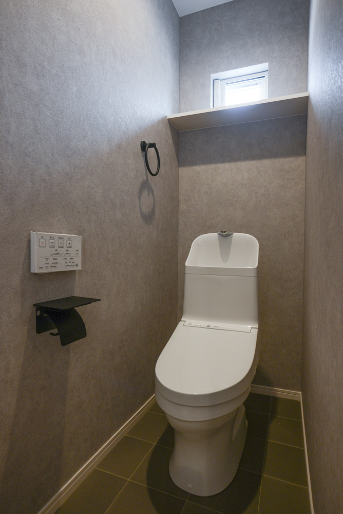 シックな２階のトイレ（壁全面クロス：サンゲツ FE74170/クッションフロア：サンゲツ HM-11108/便器：TOTO ZJ1/ペーパーホルダー・タオルリング：施主様支給品）