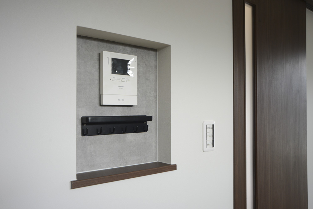 ダイニングにあるニッチ(下枠:DAIKEN hapia ダルブラウン/背面クロス:シンコール BA7237/キーフック:ブラック)※101号室